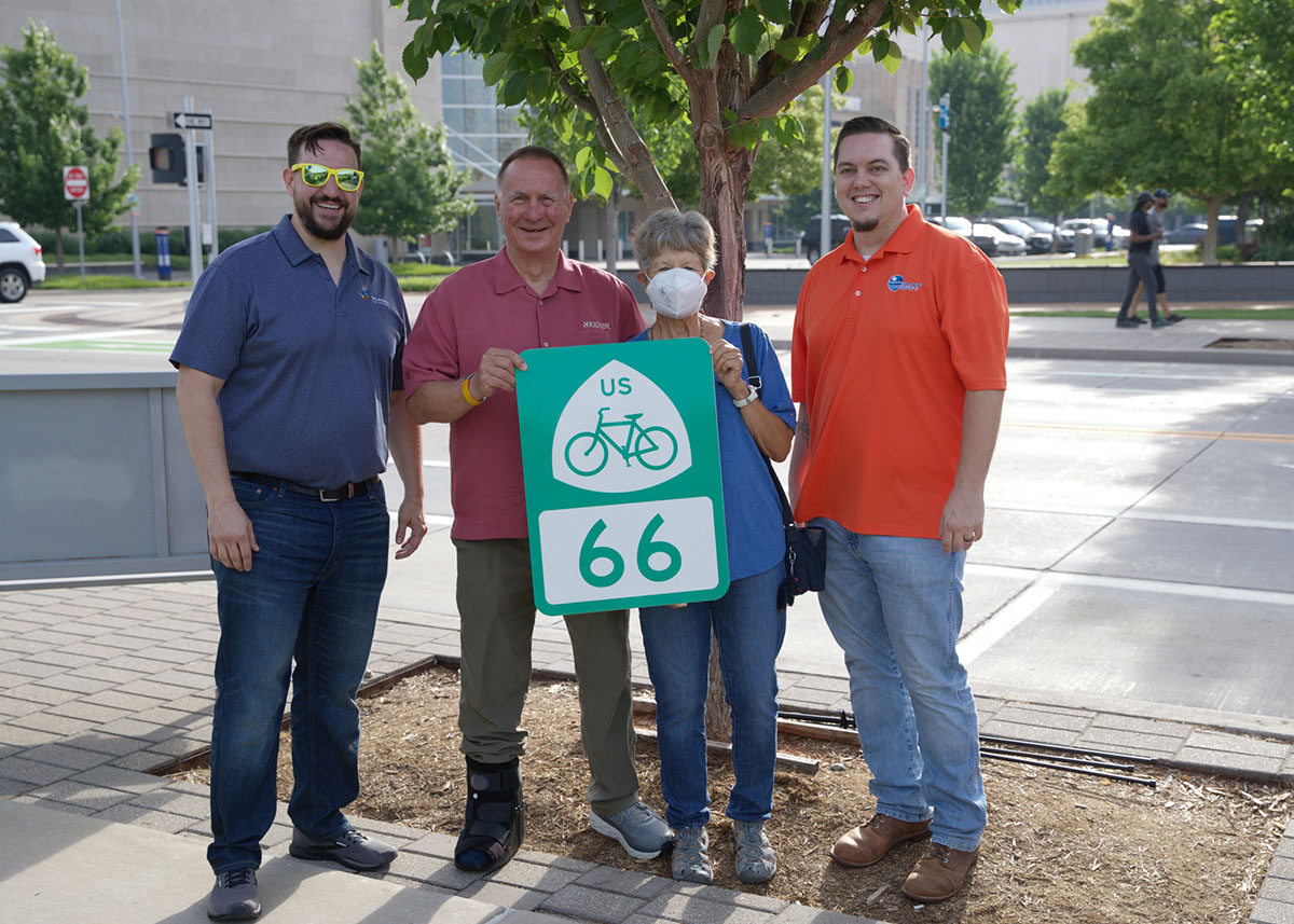 four people holding USBR 66 sign in Oklahoma