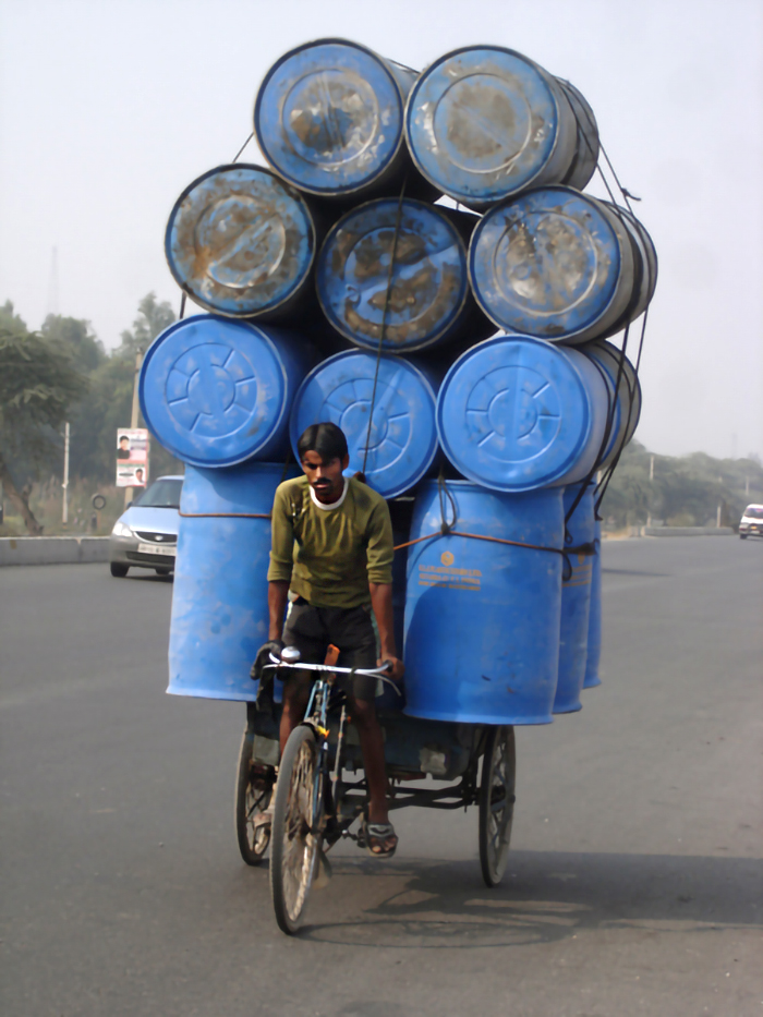 Indian man on an overloaded bicycle