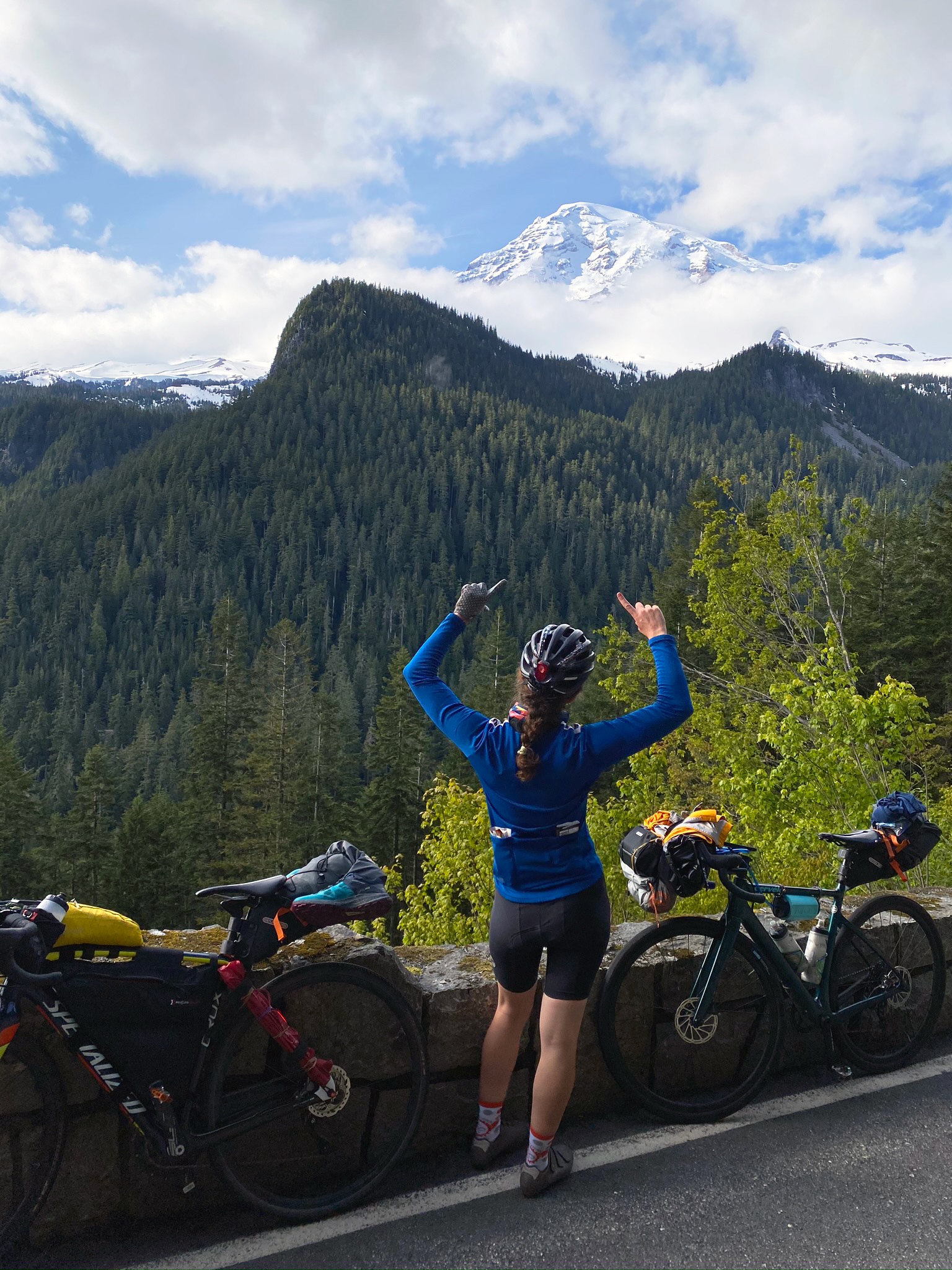 Mary points at Mount Rainier riding the Washington Parks II route