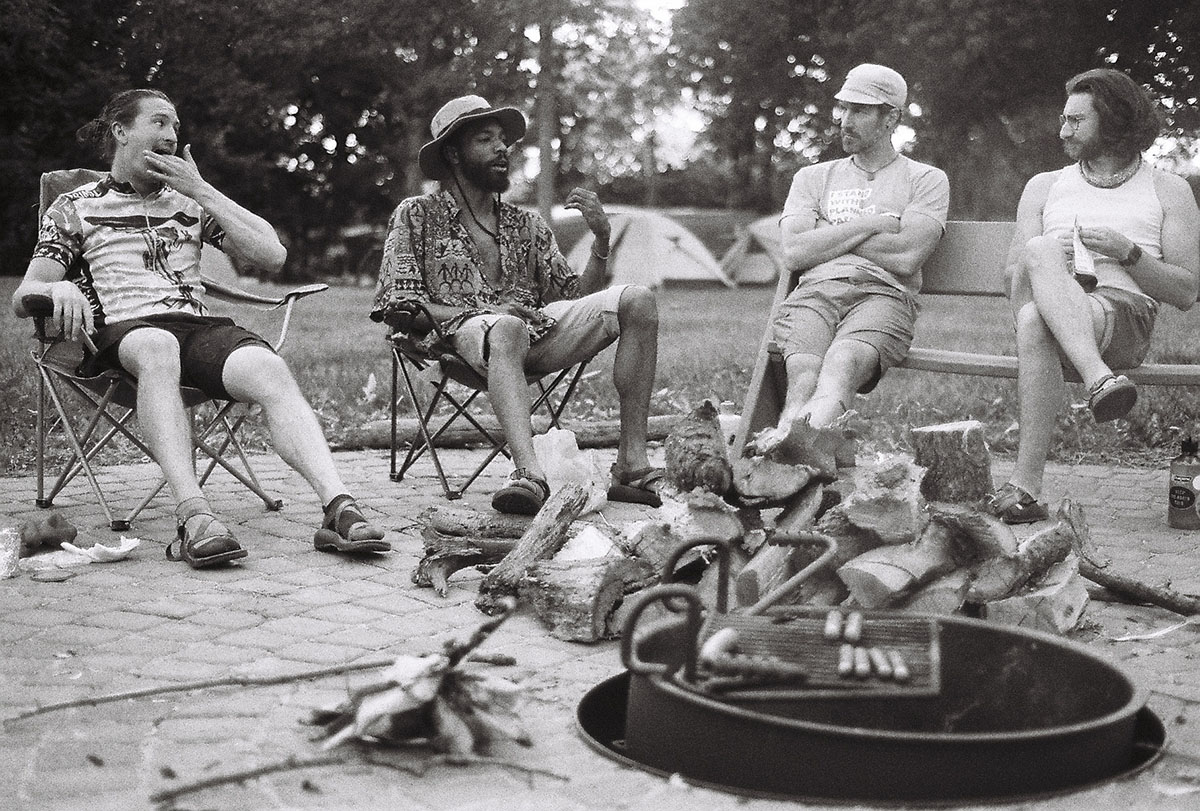 A group of young men sit around a fire and chat after their day in the saddle.