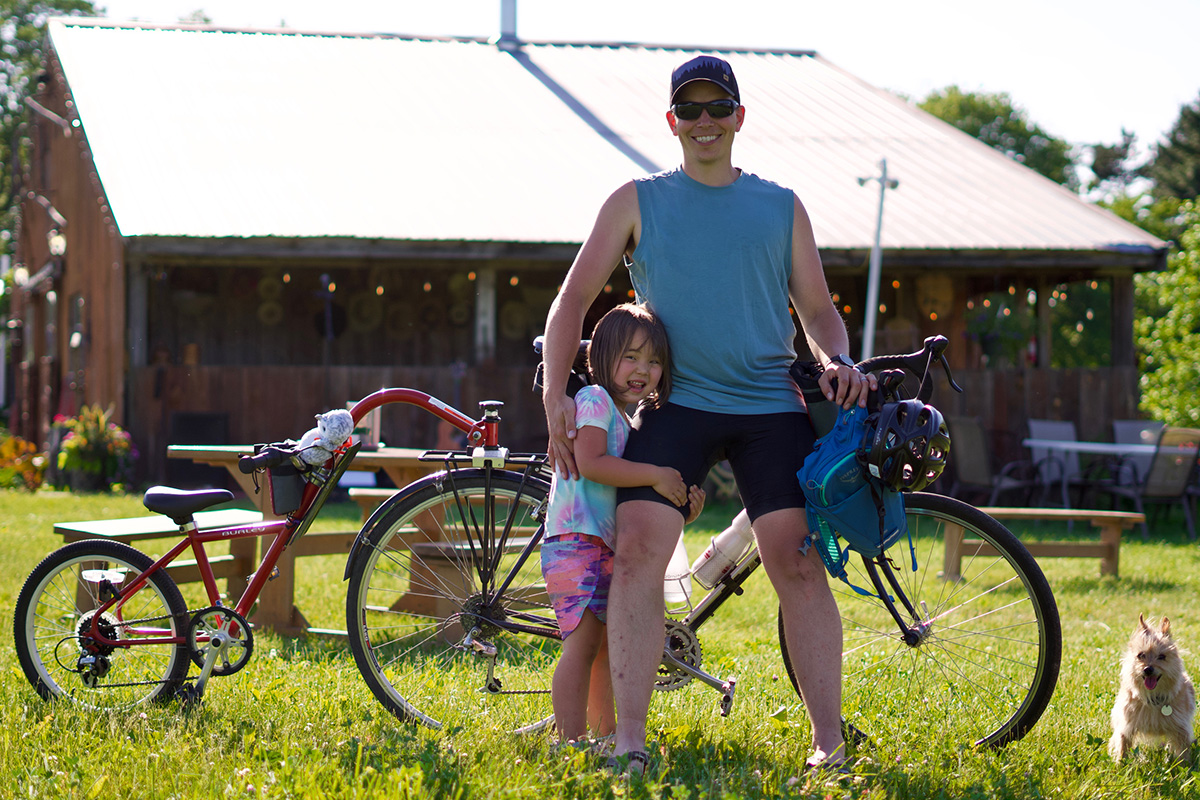 Phil and his daughter stand with their bikes at the pizza farm