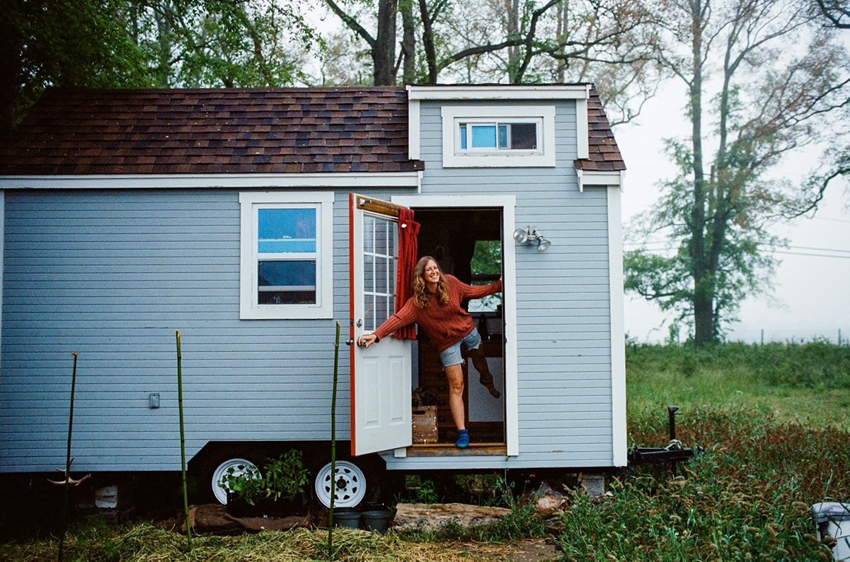 Laura stands in the door to her tiny home on wheels