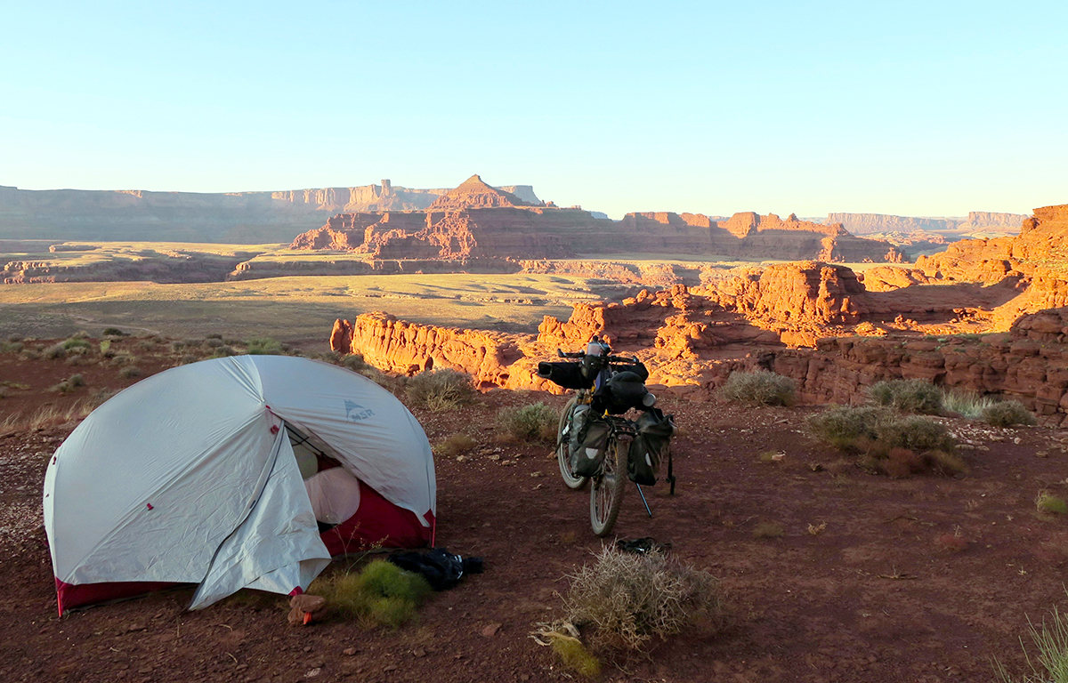 A campsite overlooked beautiful Canyonlands National Park, complete with loaded bike and tent