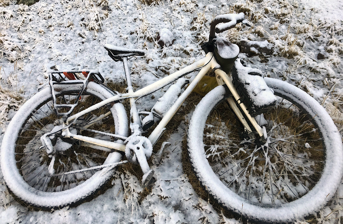 Hollie's bike is covered in a fresh layer of snow after a night of camping.