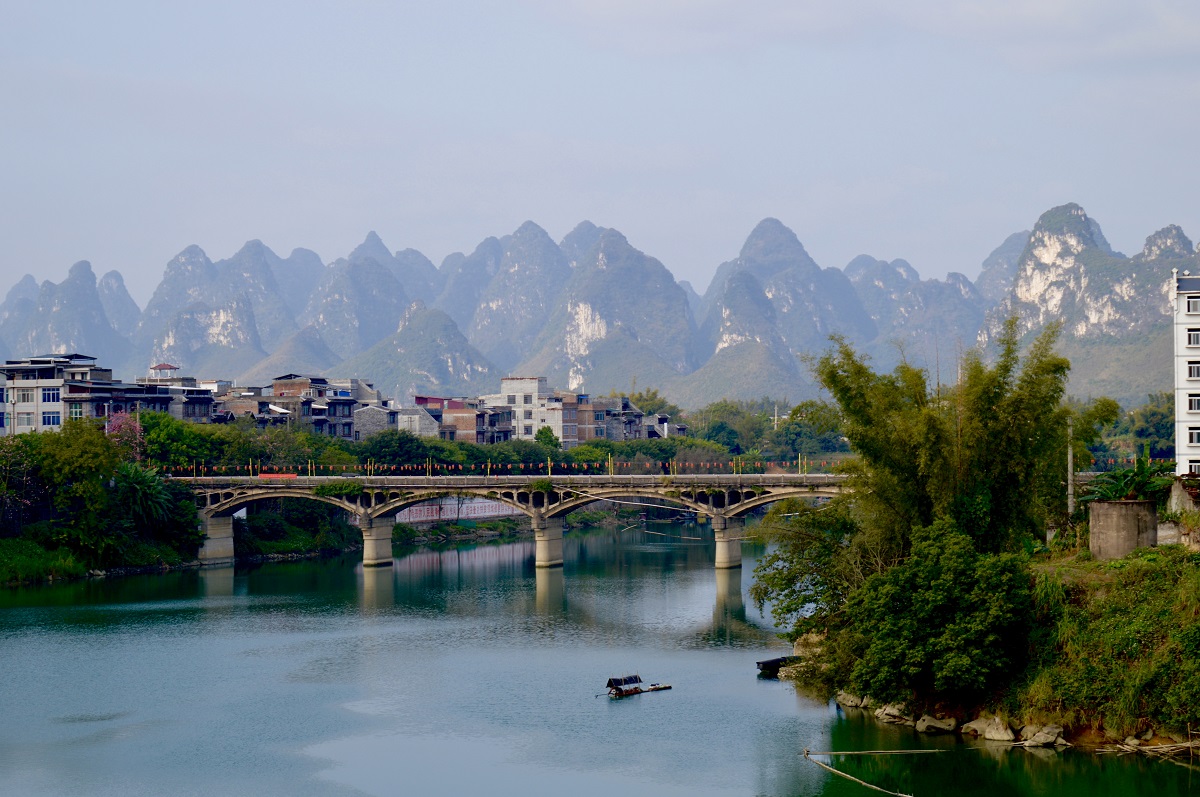 A city view of a lovely bridge over a quiet river in southern Guangxi province of China.