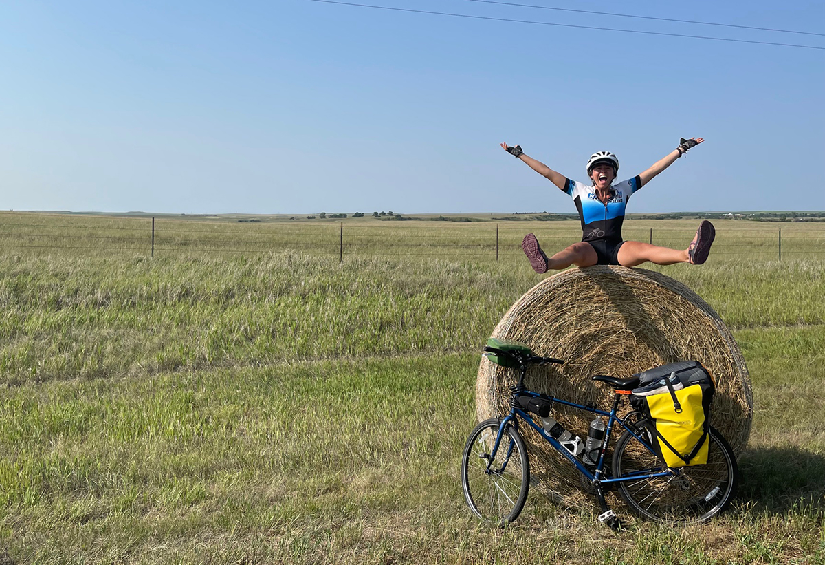 Liliana sits atop a haybale in her cycling outfit