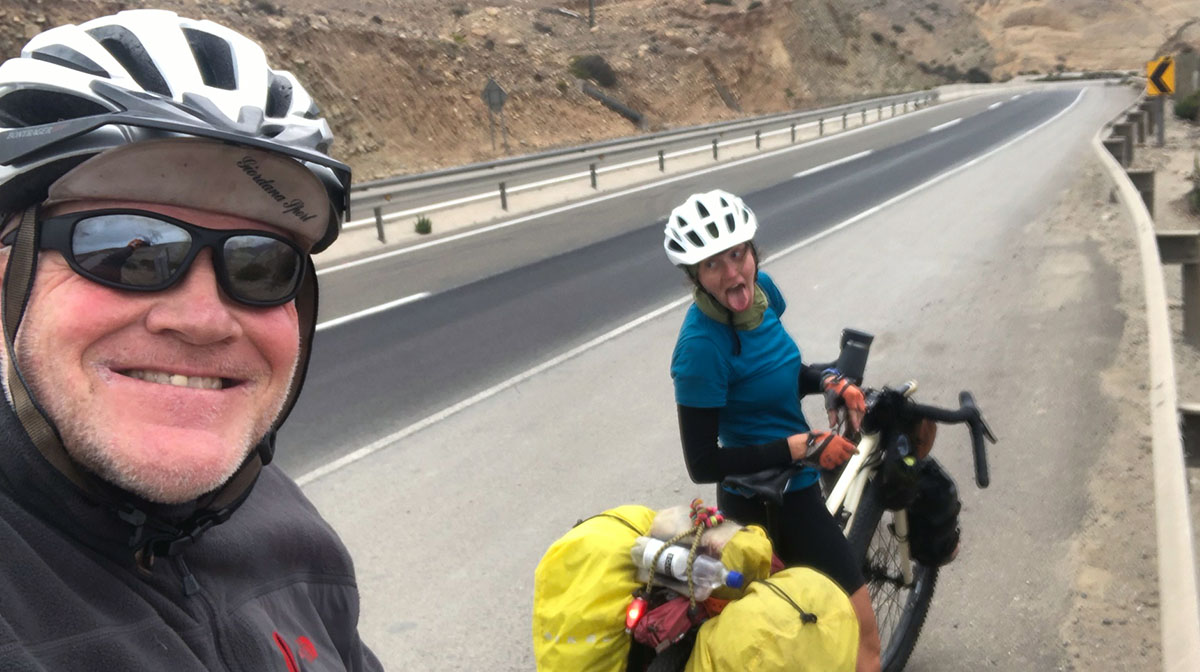 Dad takes a selfie of him and Hollie on their bikes during the trip. They are both wearing helmets and Hollie is making a goofy face with her tongue sticking out.
