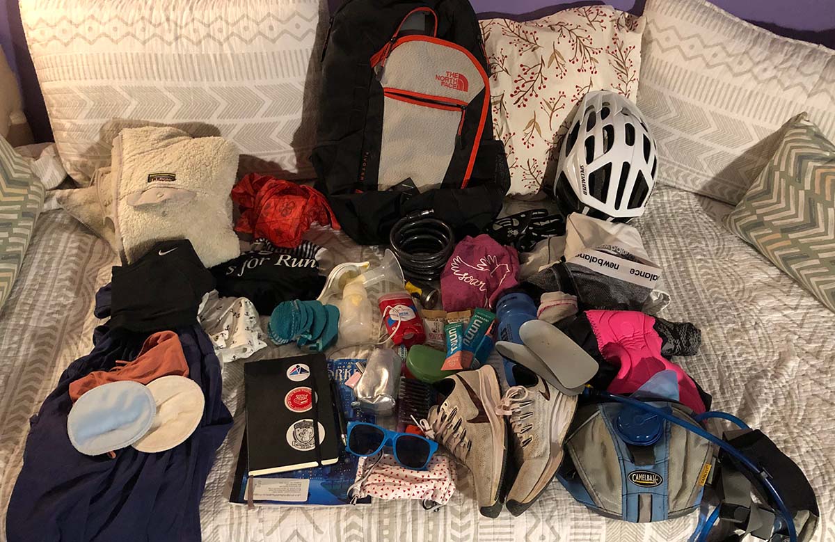 Marissa has laid out all of her gear she will pack for her trip on her white couch.