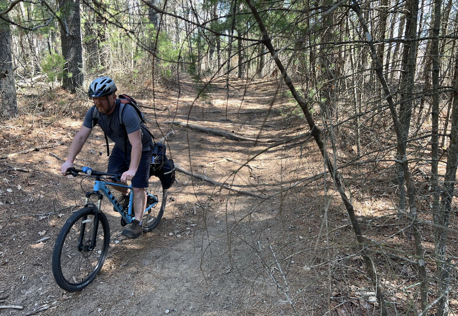 a cyclist rides a section of trail on a blue bike