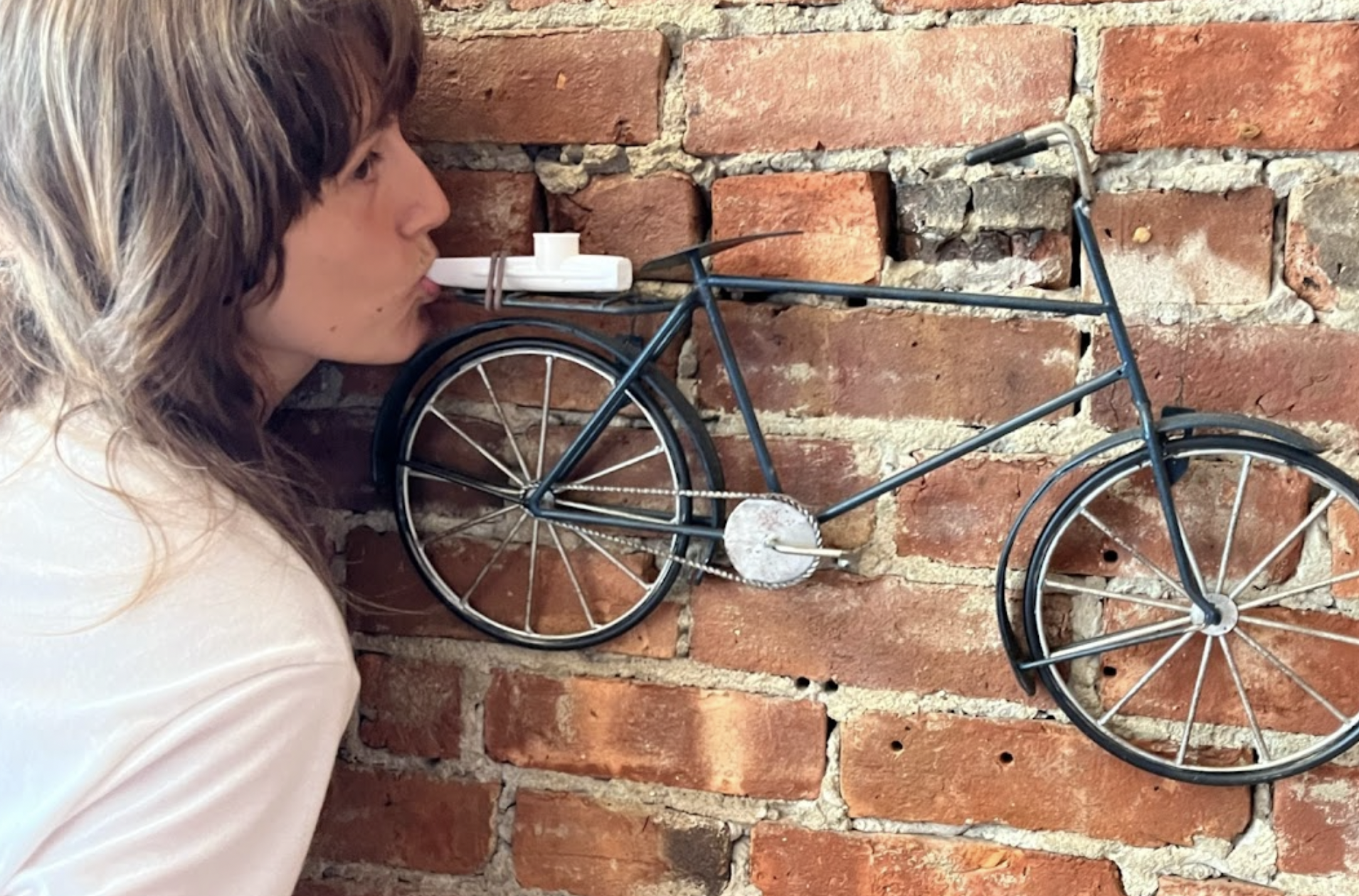 a woman with a kazoo in front of a brick wall