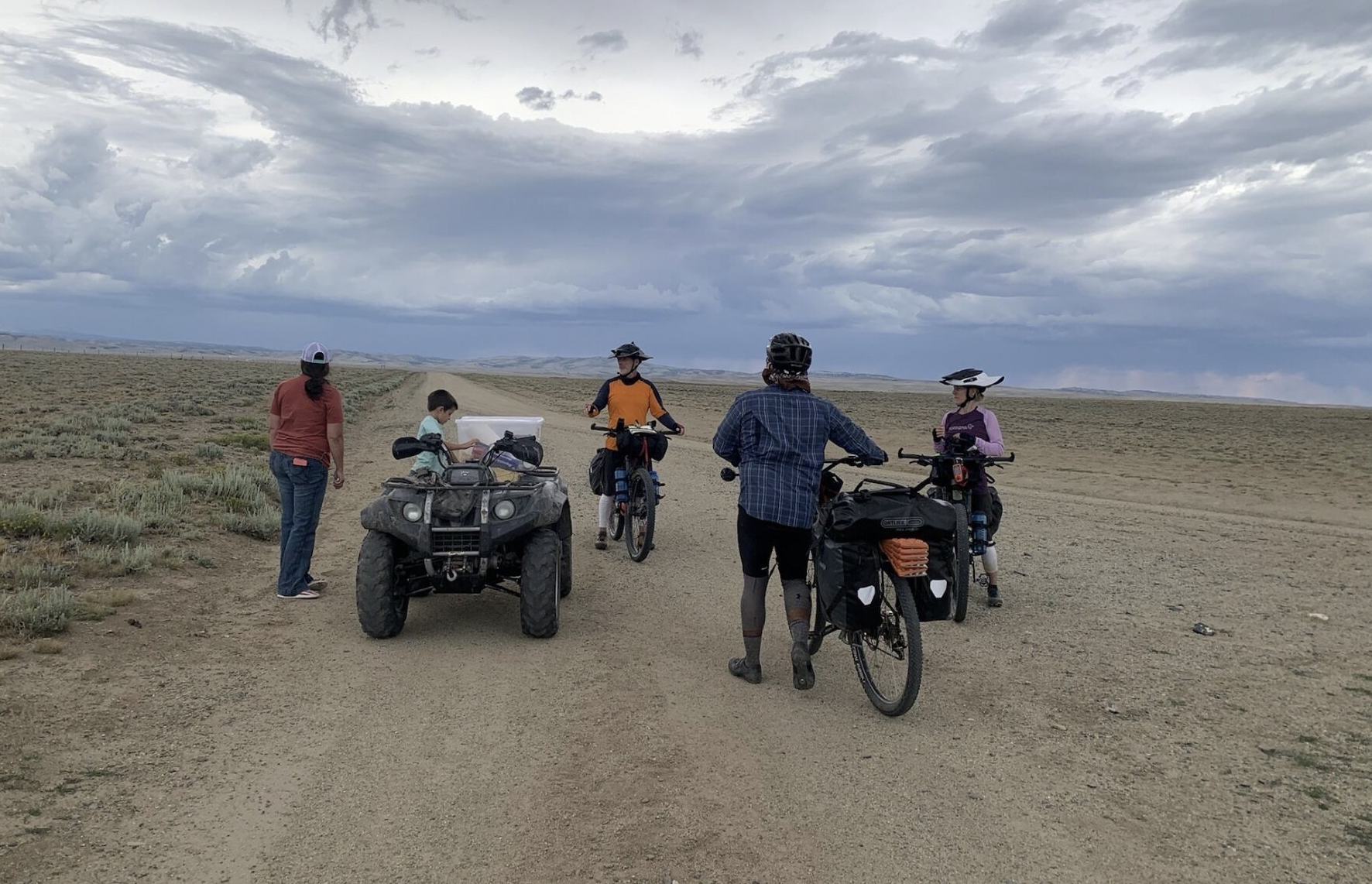 an ATV next to cyclists in a desert setting