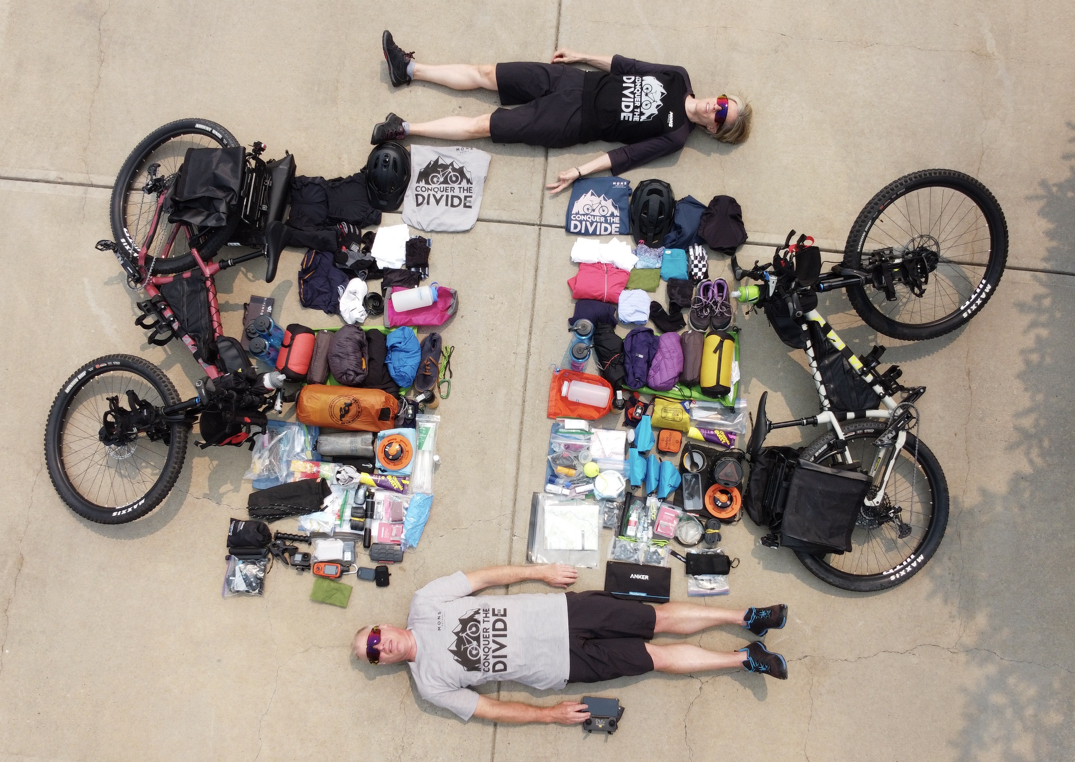 two cyclists lie with their bikes and gear, pictured from above 