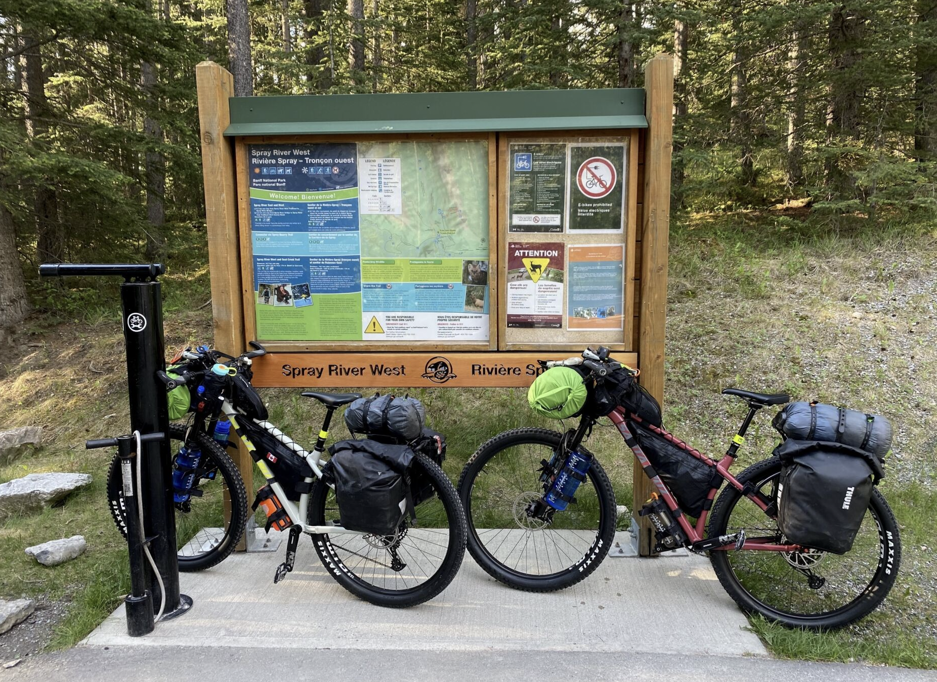 two bikes lean against a trailhead sign