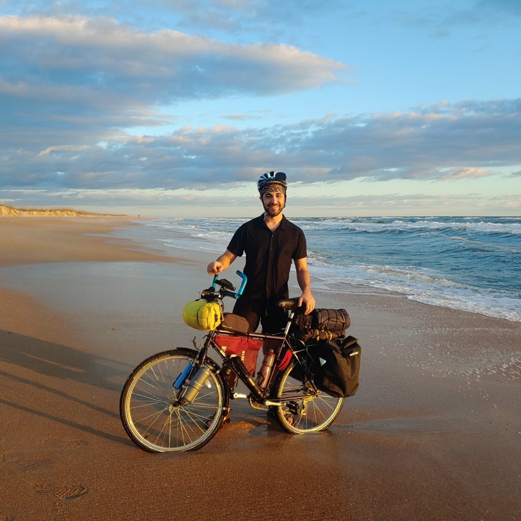 man on beach with bike