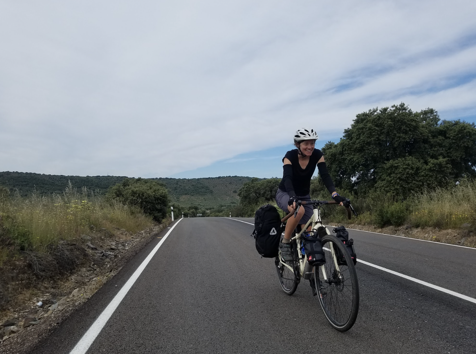 cyclist on a road with the horizon in the background 