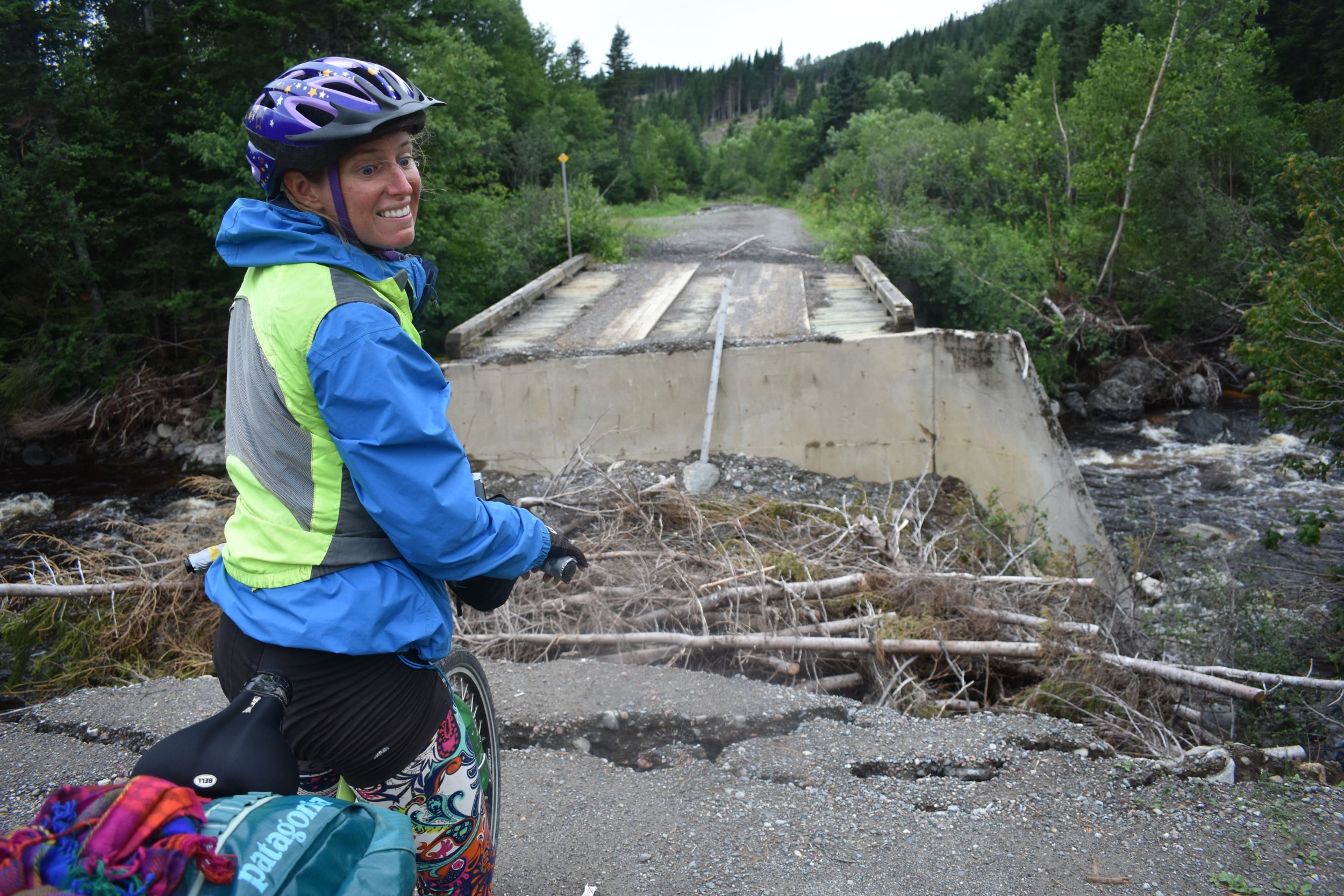 Laura grimaces in front of a washed out bridge