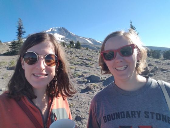 Two women smiling at the camera in a rocky landscape.