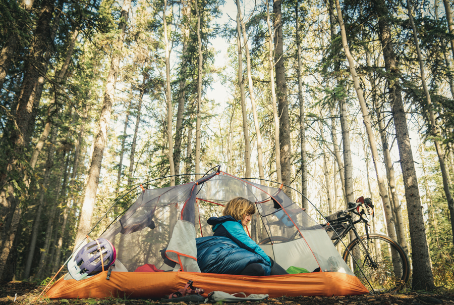 Elsa Sebastian gets ready for a beautiful day in her tent while riding through the Yukon