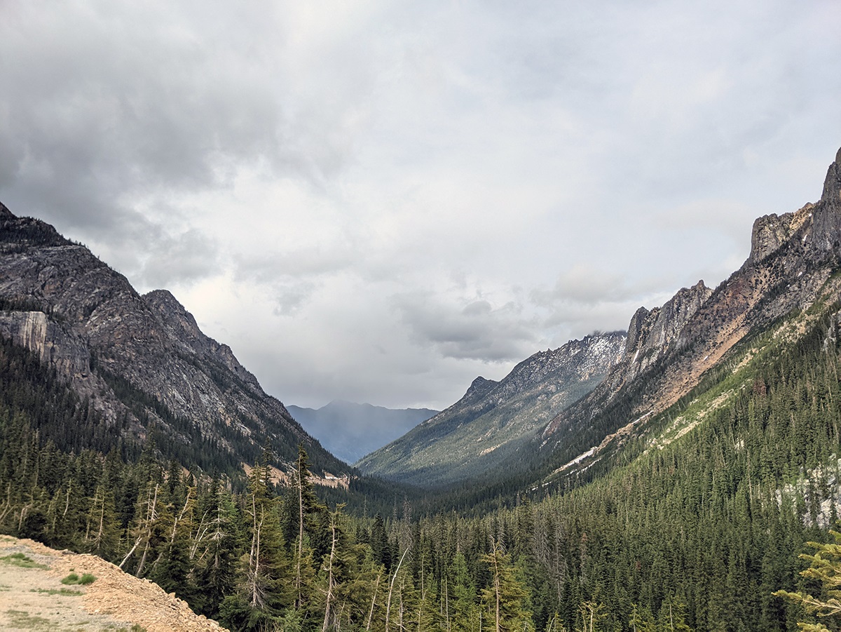 A big mountain valley with ominous gray clouds overhead