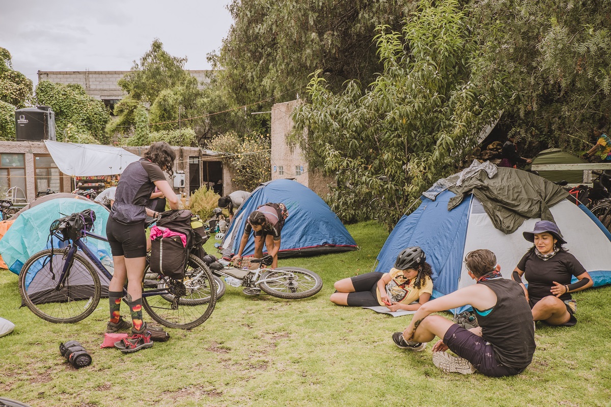 A view of the group's campsite on an area of grass with a few houses in the backcountry.