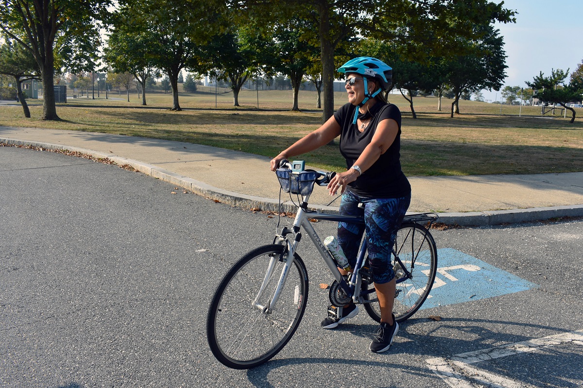 Y.O.U. Executive Director Bernadette Souza stands astride her bike, ready to lead the charge