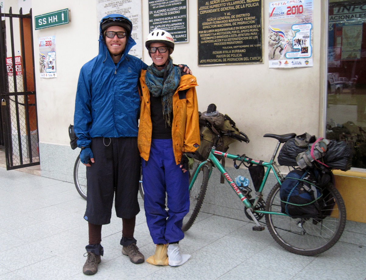 Laura and her riding partner dress in mismatched clothes and cover their feet in plastic bags to keep them dry while on a bike tour on used bicycles.