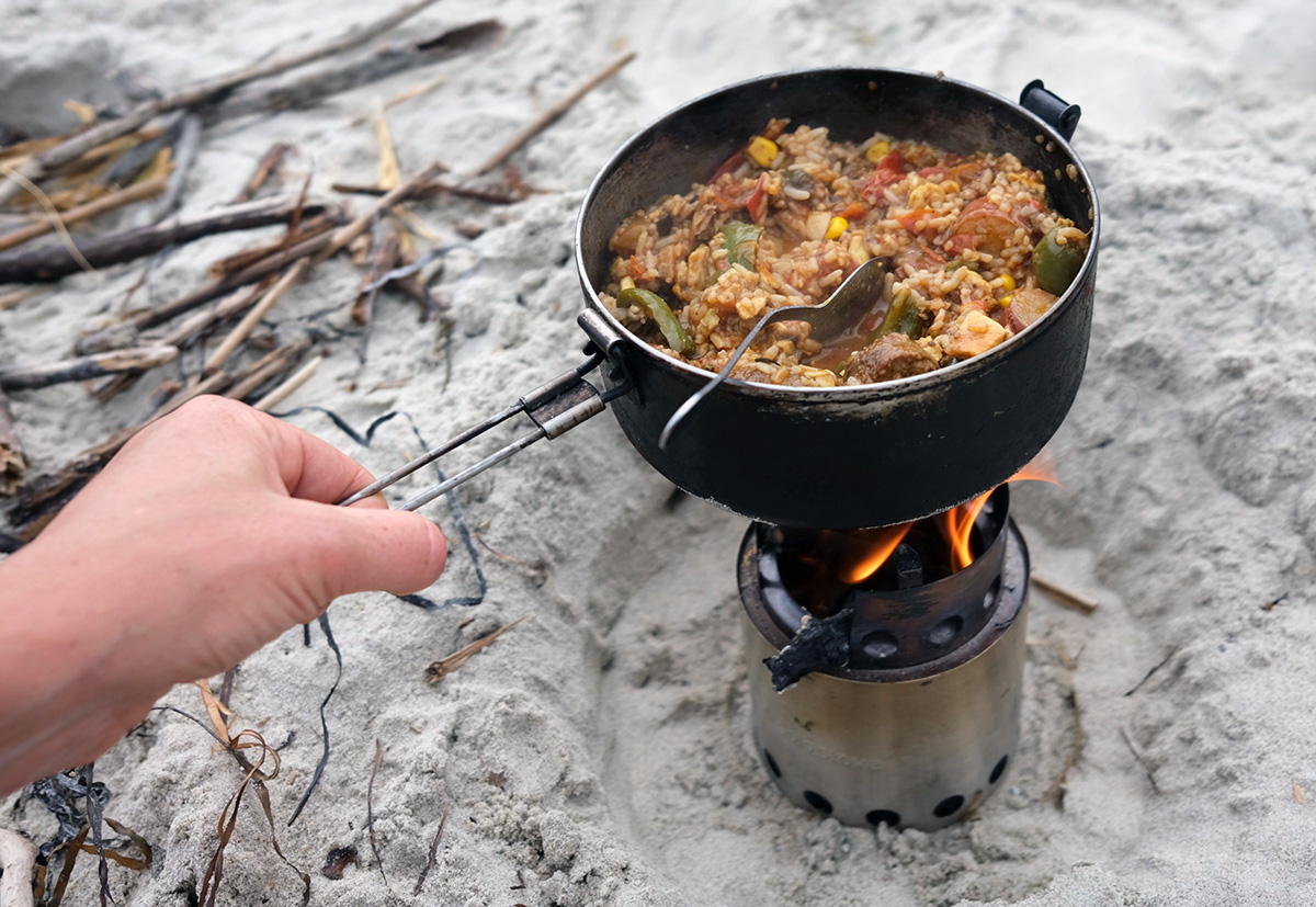 Laura heats a rice dish over a wood-fired Solo Stove