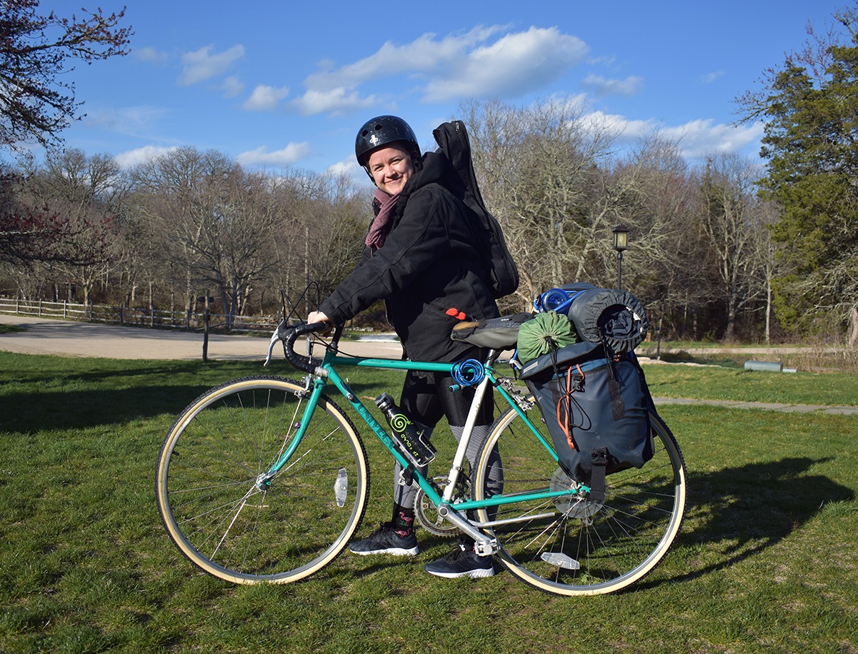 Laura's friend stands with her bike loaded with whatever bags she could find at home.