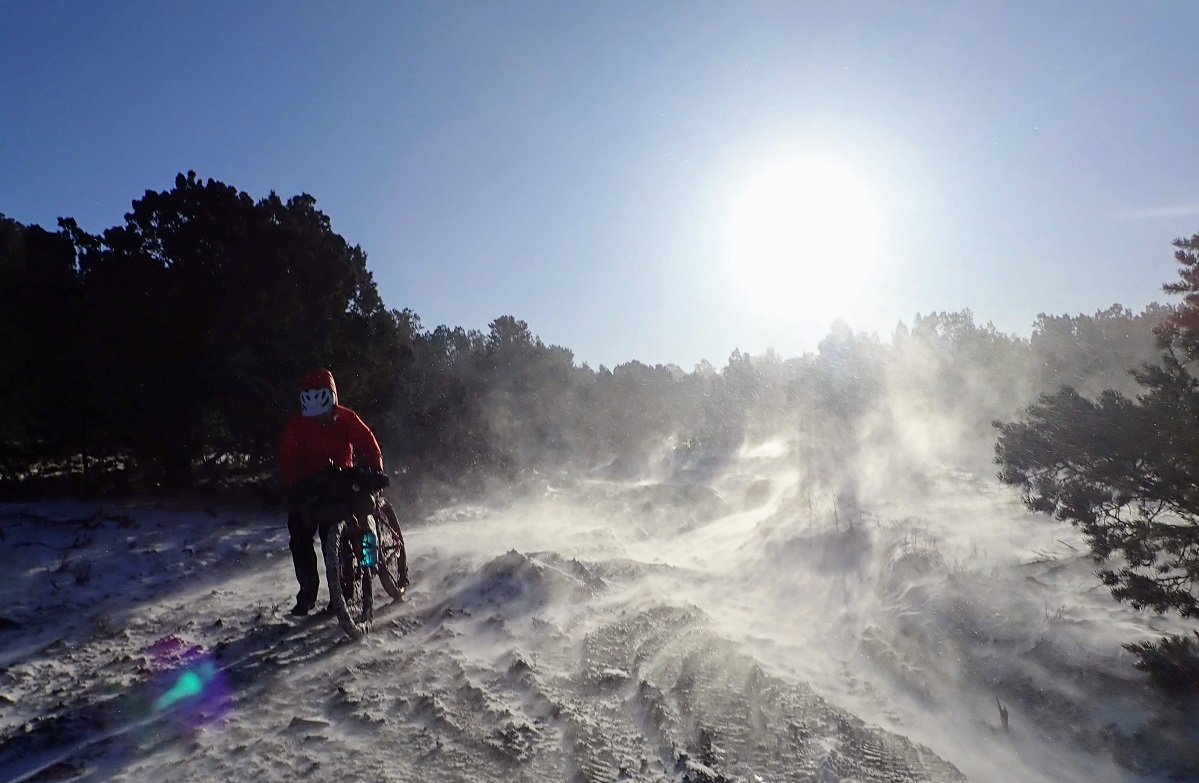 Alissa pushes her bike through a blizzard in New Mexico