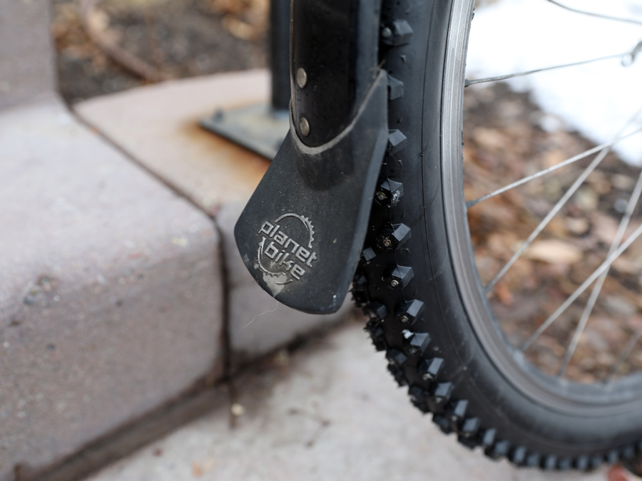 A rubber mud flap attached to a plastic full-length fender