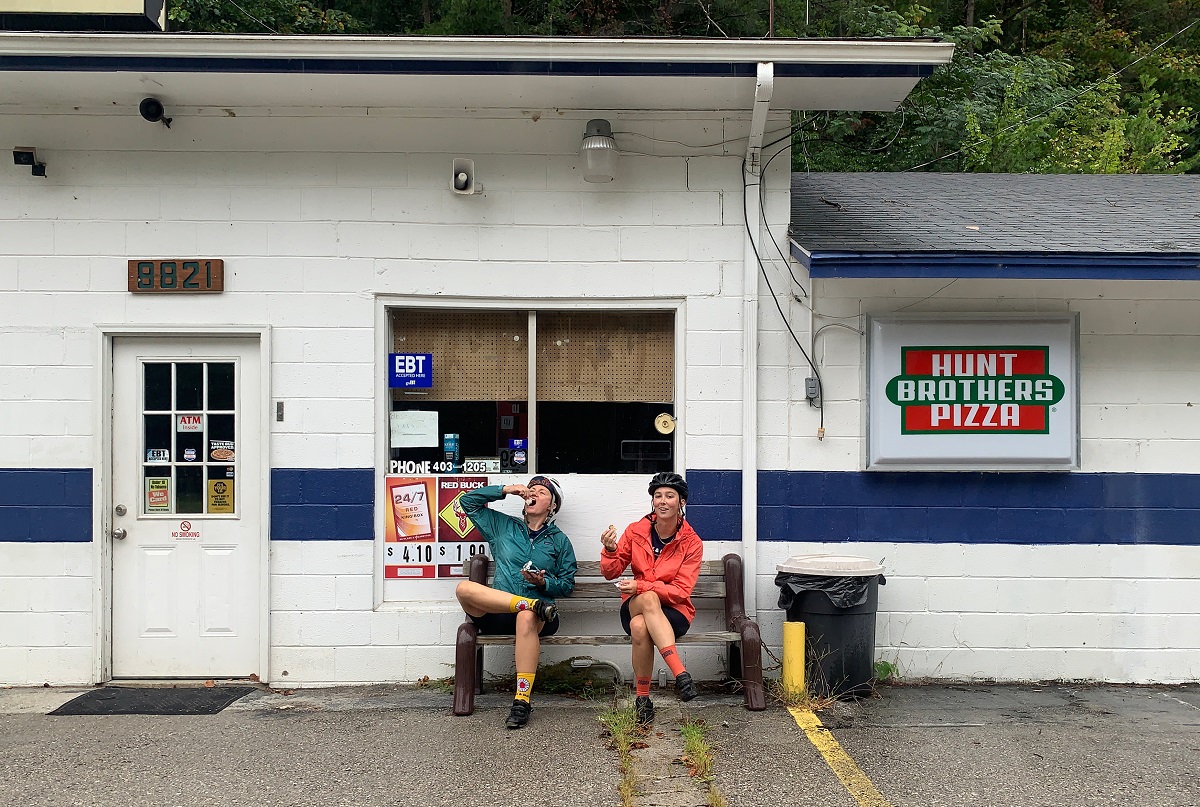 Sydney and Amanda sit in front of a convenience store and chow down on junk food.