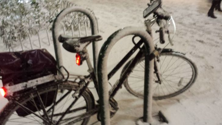 A bike covered in snow at night