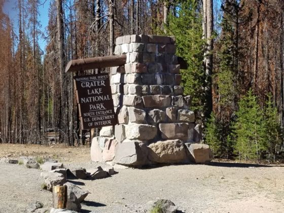 rock structure holding wooden sign for Crater Lake National Park
