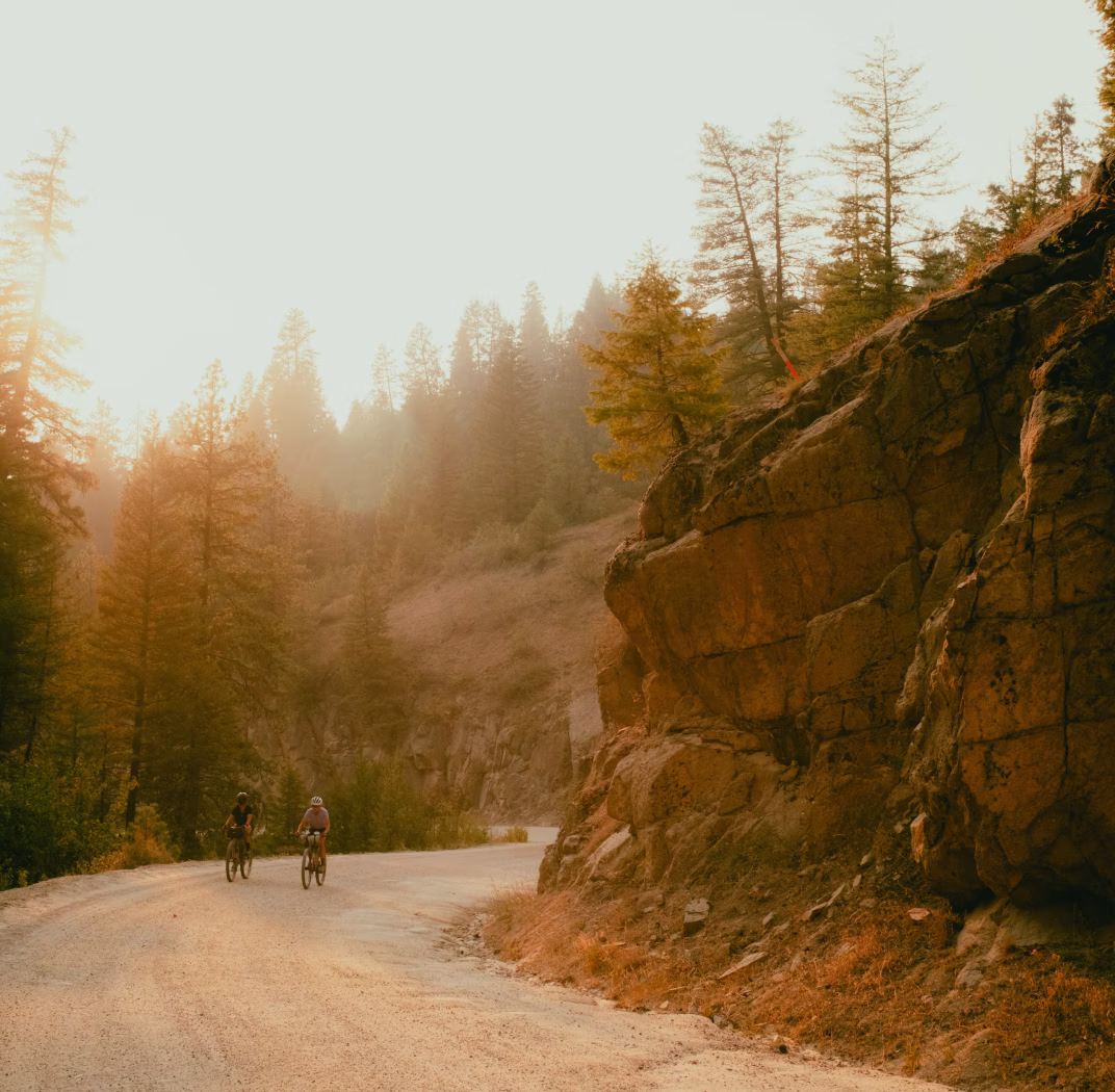 Riders on dirt road near rocky cliffs